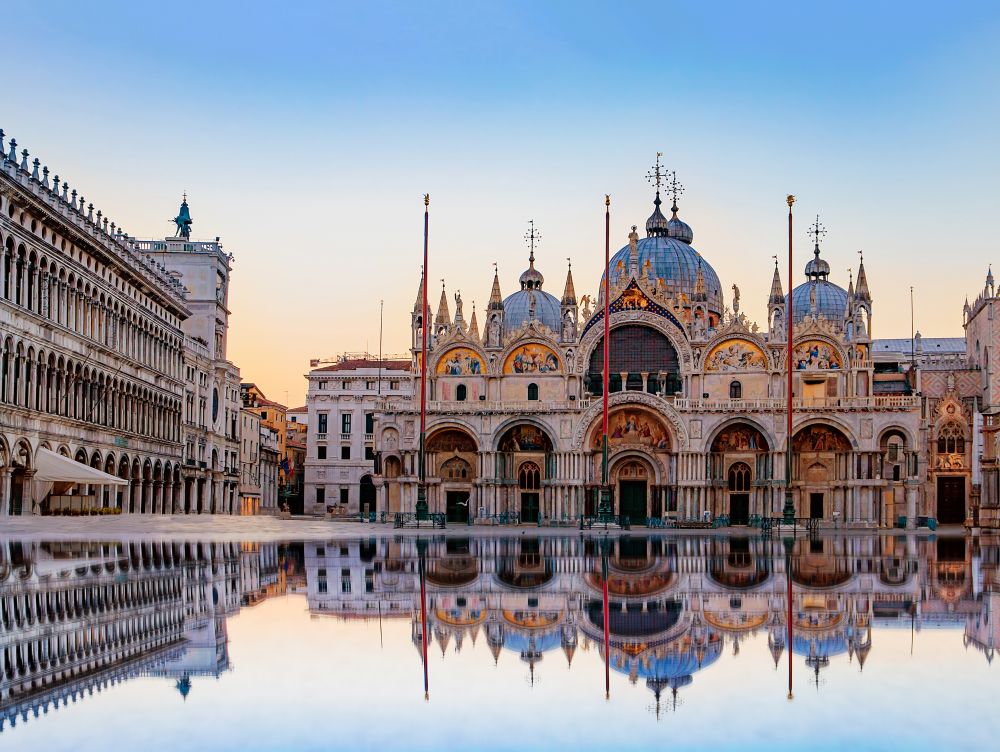 Sunrise in San Marco square with Campanile and San Marco's Basilica. The main square of the old town. Venice, Veneto Italy. Reflection on the flooded square.