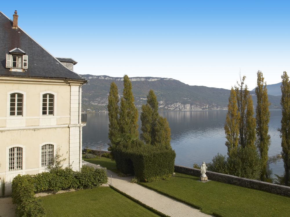 un écrin de verdure s'offre au regard vers le sud sur le lac et la montagne du Revard / abbaye de Huatecombe