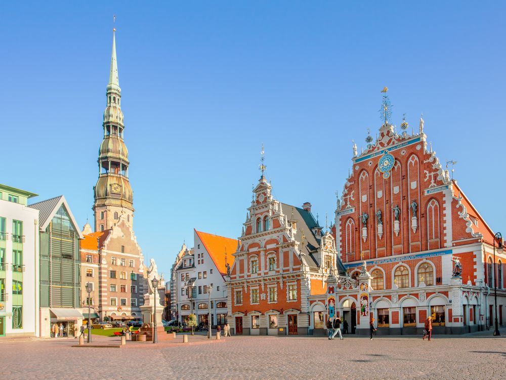 RIGA, LATVIA - September 9, 2008: Tourists admiring Town Hall Square with House of Blackheads and St Peter's church in Riga, Latvia.